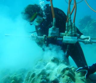 Kim Cobb drills corals underwater in the tropical Pacific